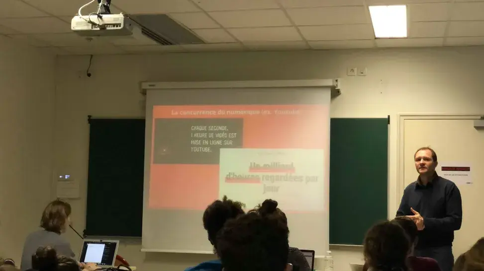 Photographie de Gilles Freissinier faisant une présentation à des étudiants.